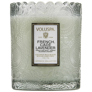 A coconut wax candle in a glass with scalloped edging french cade lavender fragrance volupsa