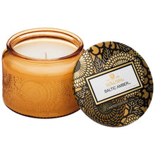 A coconut wax candle in a decorative glass jar baltic amber fragrance voluspa