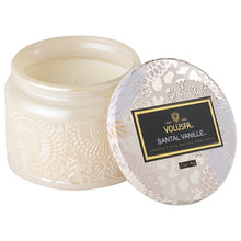 A coconut wax candle in a decorative glass jar santal vanille fragrance voluspa